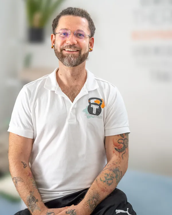 Porträt von Andy Hoffmann, herzlich lachend, im Polo mit dem BodyMind-Logo.