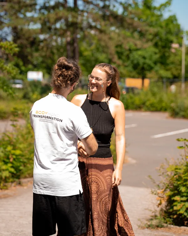 Andy im Gespräch mit einer Frau draußen im Tageslicht.